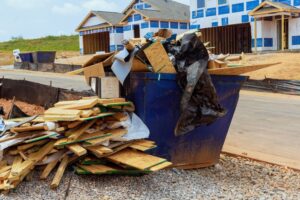 dumpster filled with wood near house being built