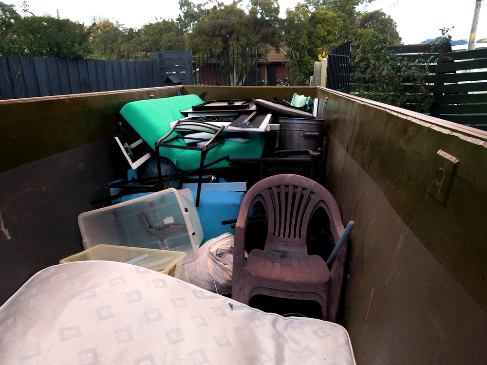 chairs and furniture in a roll off dumpster