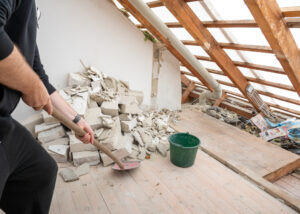 brick debris in attic with man holding a shovel