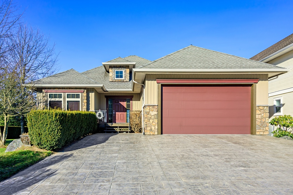 Clear residential driveway with red garage door
